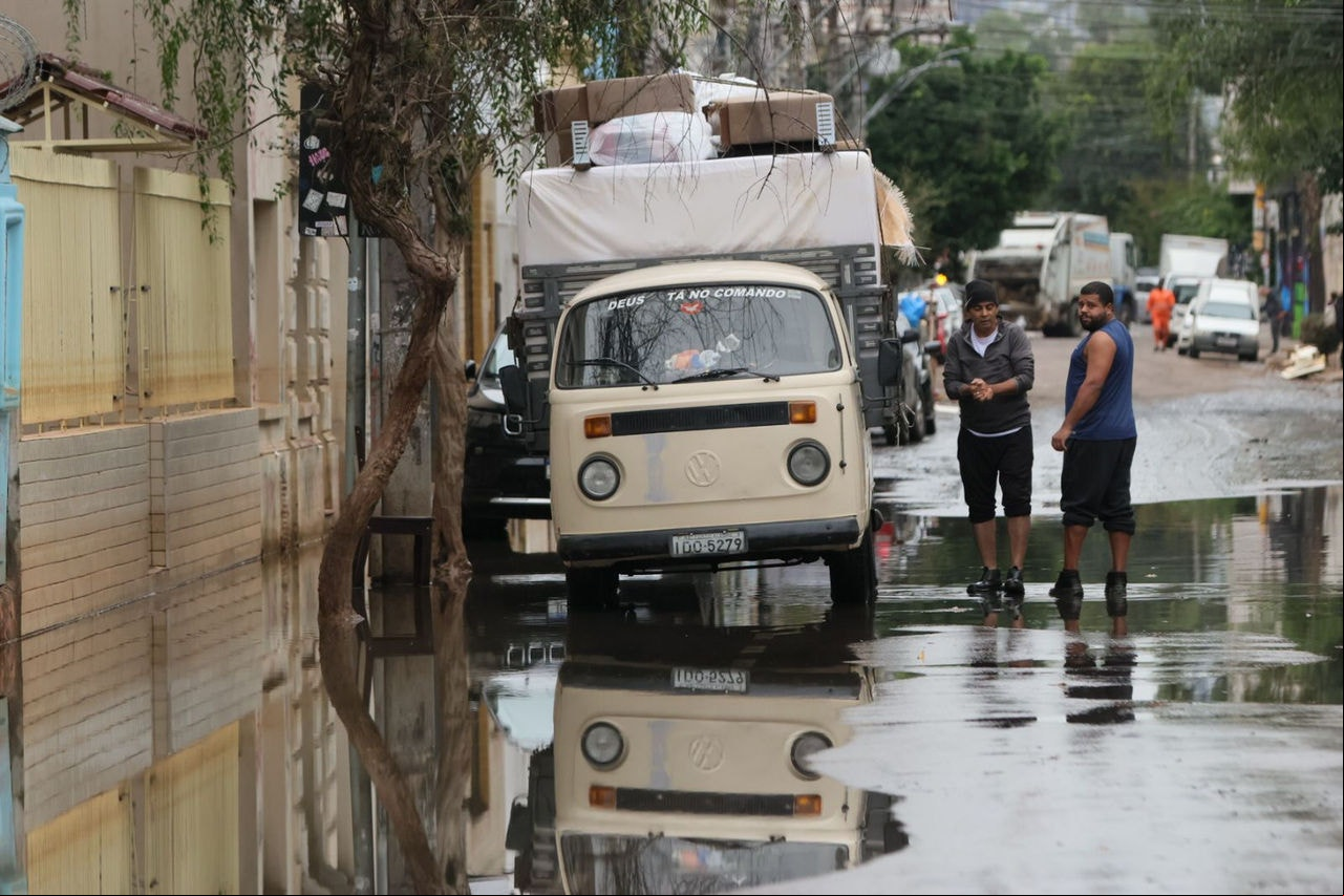 Moradores da Cidade Baixa, em Porto Alegre (RS), tentam limpar casas em meio ao esgoto que tomou ruas