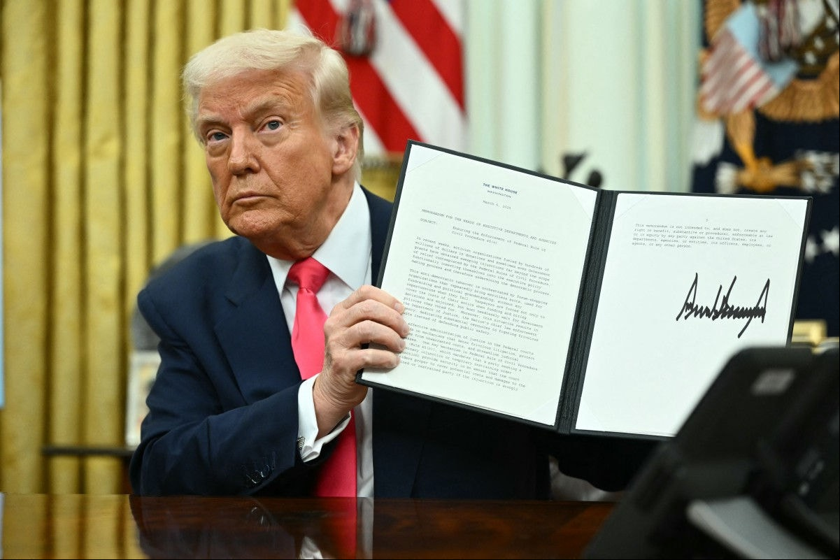 US President Donald Trump signs an executive order in the Oval Office of the White House in Washington, DC on March 6, 2025. (Photo by Mandel NGAN / AFP)