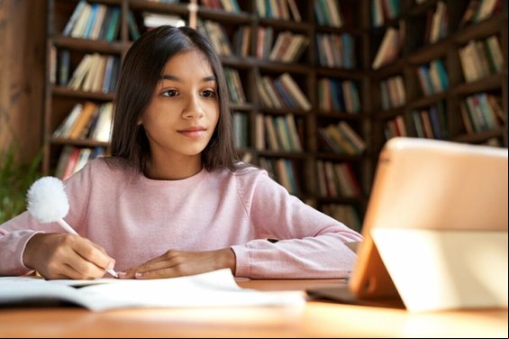 Menina sentada estudando em uma biblioteca
